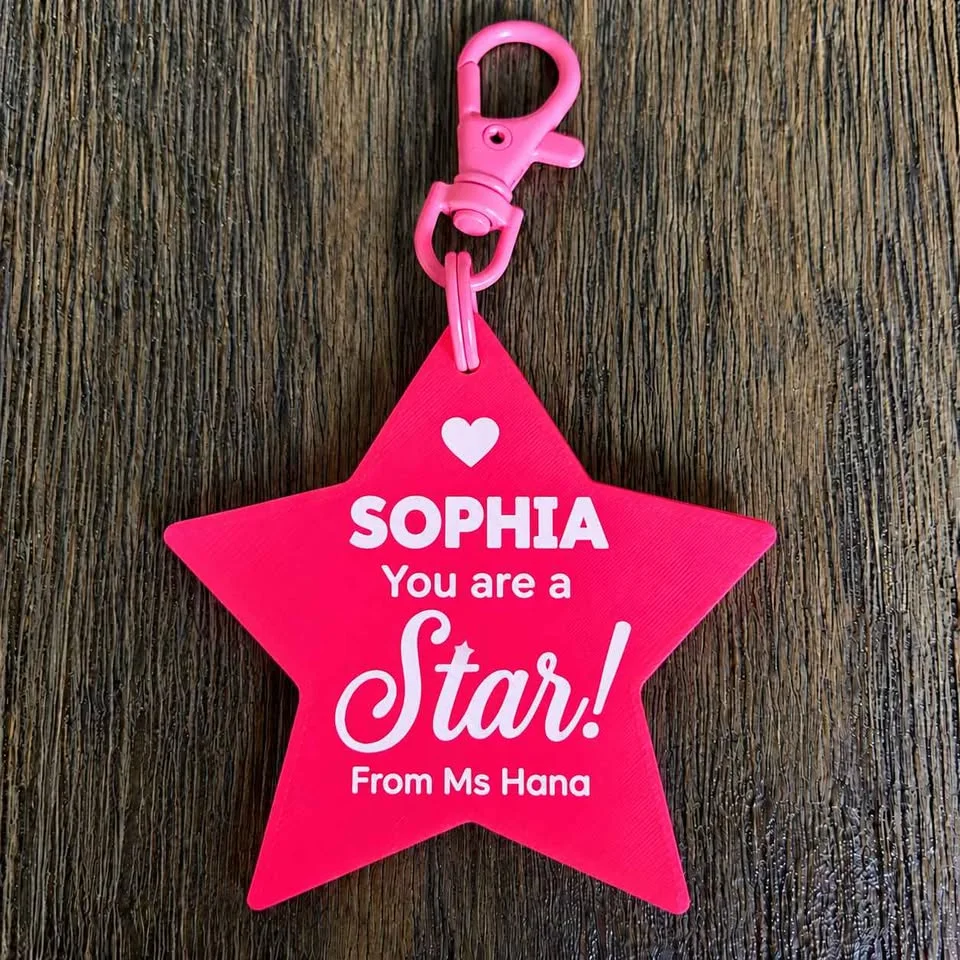 Pink "You are a Star" keychain with a student's name and the teacher's name