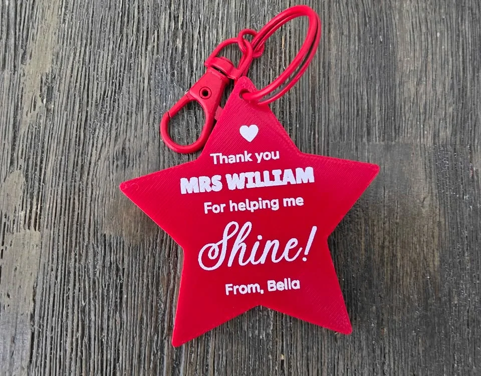 Red star keychain printed with a thank-you message to a teacher and the student's name