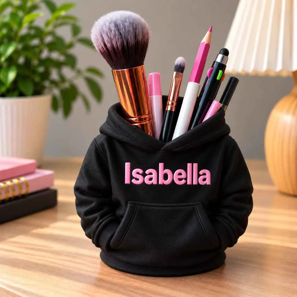 Illustration: black hoodie pencil holder with a pink name, holding pens and pencils